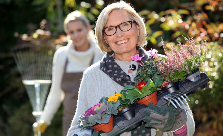 A mother holding a basket of flowers, a perfect Mother's Day garden gift.