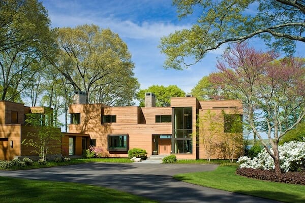 Feature image A modern home nestled among giant trees and a lush carpet of grass.