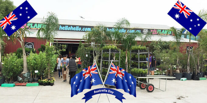 A group of people celebrating Australia Day standing in front of a store with Australian flags.