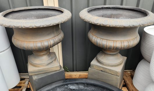 Two GardenLite Wide Urn IronOre 63x56cm sitting next to each other.