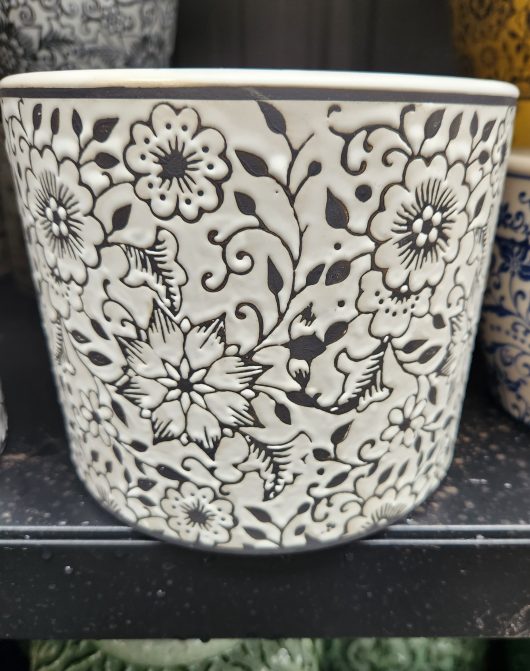 A Tang Mini Cylinder Floral Black L 18x15cm flower pot sits on a shelf.