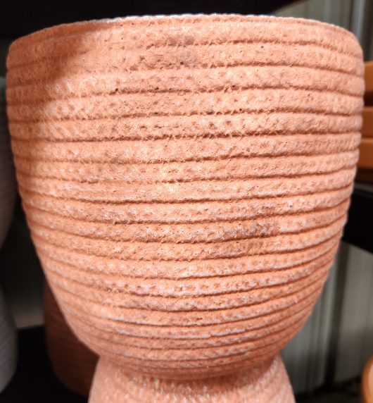 A group of Dart Weave Egg Red M 19x18cm pots on a shelf in a store.