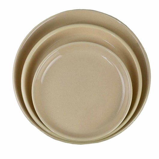 A set of three beige plates on a white background.