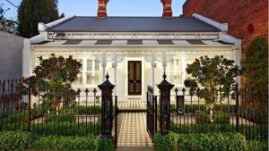 A victorian style home with a wrought iron gate.