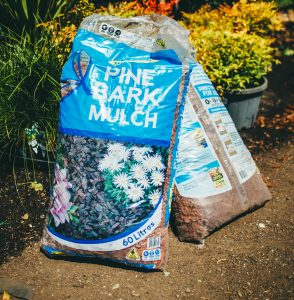 A bag of Searles Mulch Pine Bark 60L sitting on the ground.