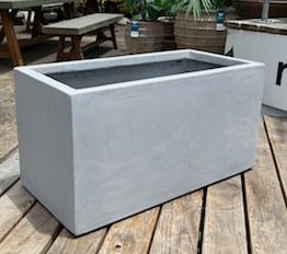 Rectangular concrete planter on a wooden deck.