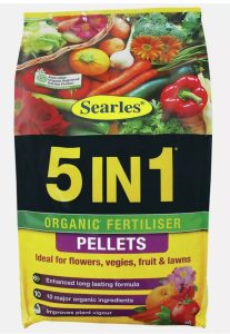 Bag of Searles '5 in 1 Plus Pellets' organic fertiliser pellets with pyrethrum, recommended for flowers, veggies, fruit, and lawns, displaying various vegetables and fruits.