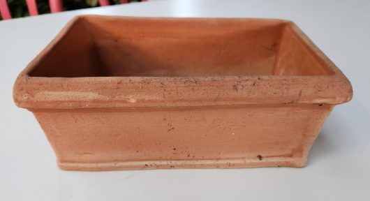 A Toscana Rustic Box Trough 26x14x11cm with softly worn edges rests on a white surface.