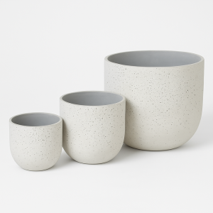 The Limecrete Egg Pot White Set of 3 is showcased in an orderly arrangement from smallest to largest against a crisp white background, featuring round, speckled light gray nesting bowls reminiscent of limecrete design.